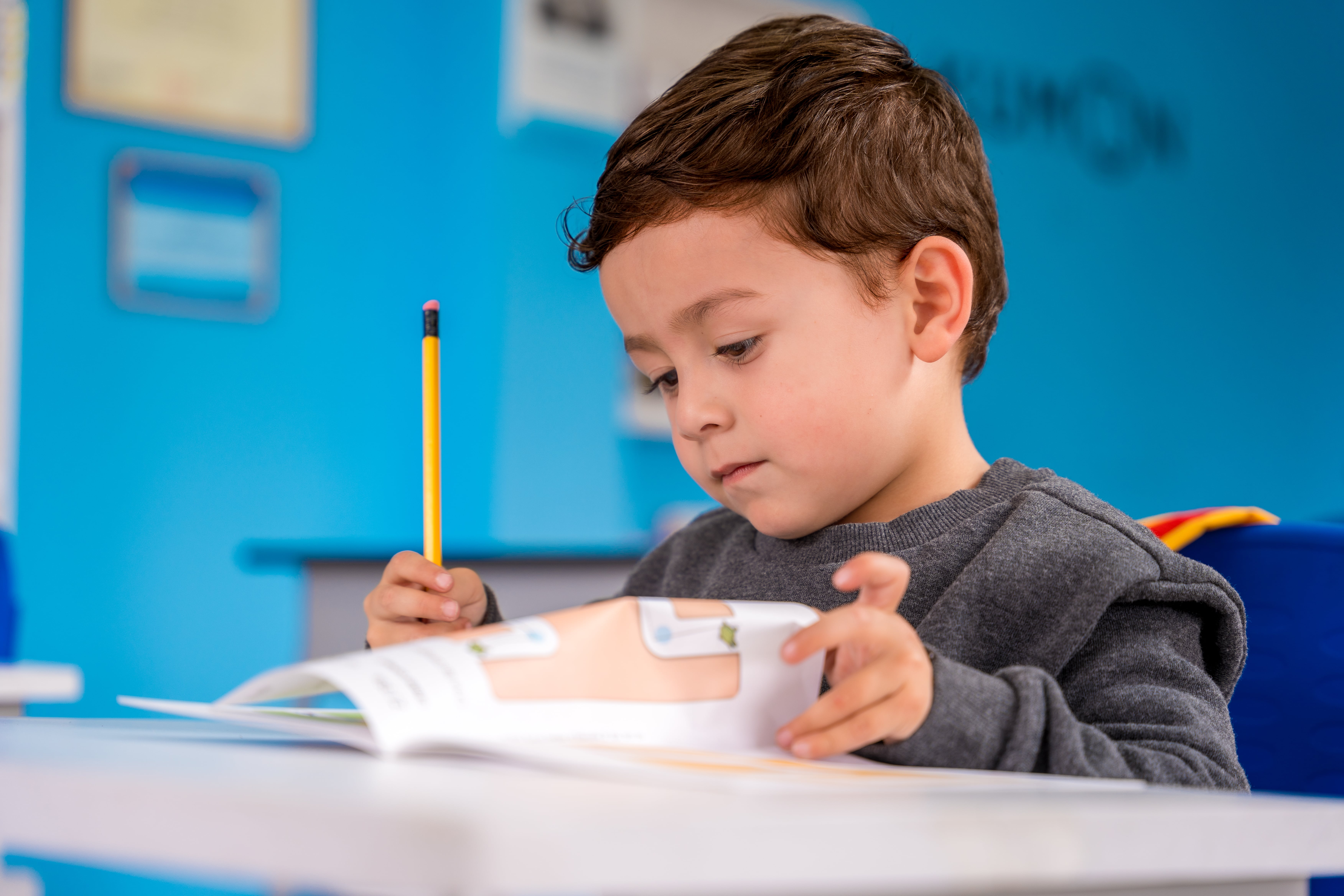 Niño en temprana edad practicando la escritura en un centro Kumon