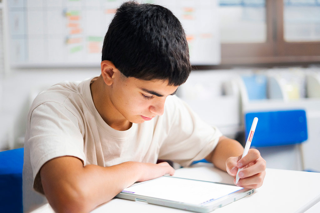 Estudiante concentrada resolviendo ejercicios en papel como parte del método Kumon de estudio individualizado-Uruguay