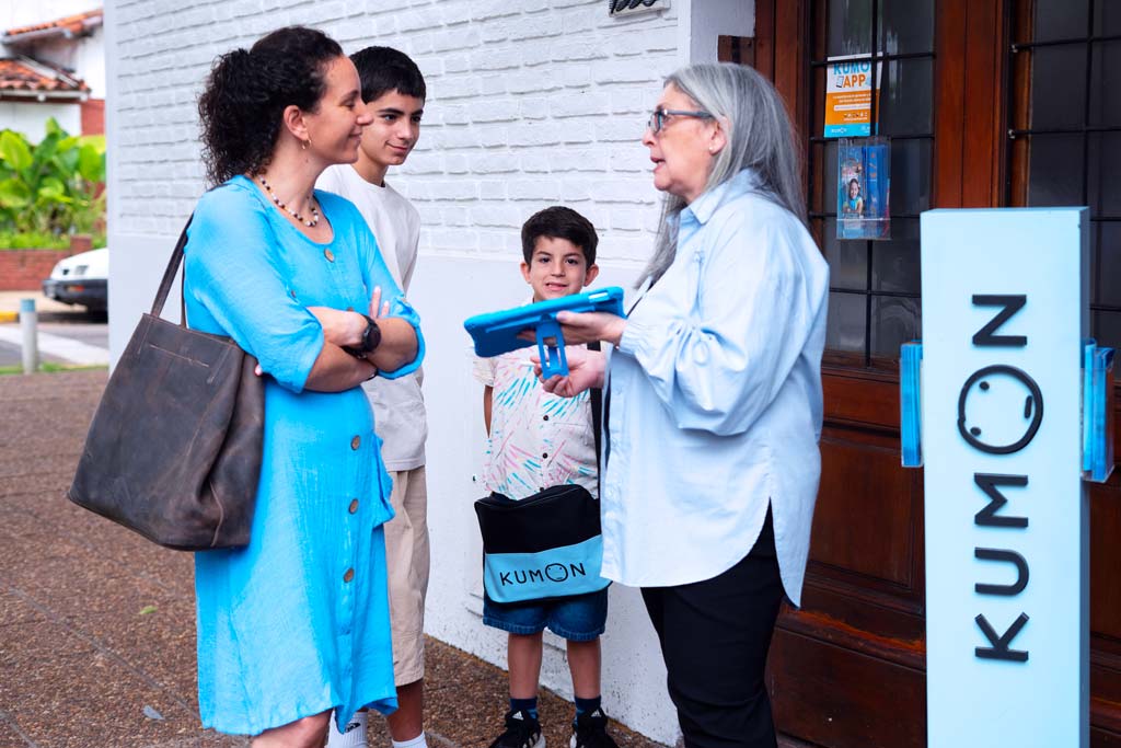 Familia conversando con una orientadora frente a un centro Kumon-Uruguay